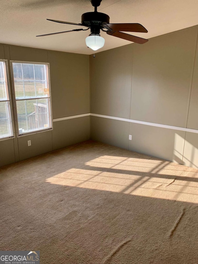 carpeted spare room with ceiling fan