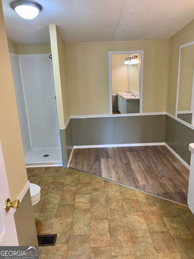 unfurnished room featuring hardwood / wood-style flooring, a textured ceiling, and washer / clothes dryer