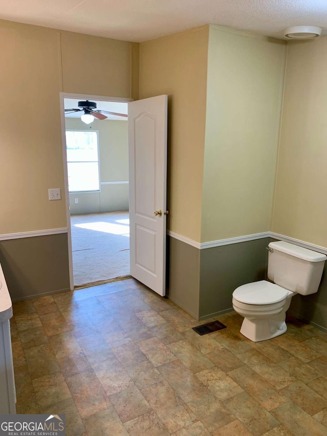 bathroom with ceiling fan and toilet