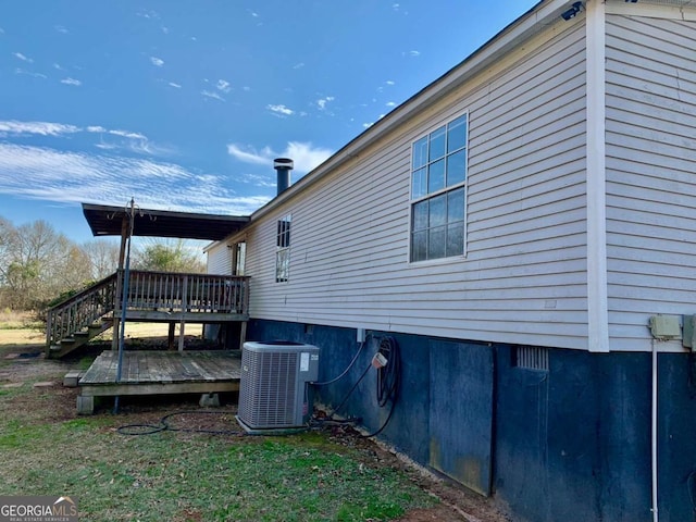 view of property exterior featuring cooling unit and a wooden deck