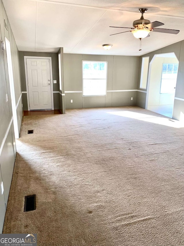 carpeted spare room featuring ceiling fan