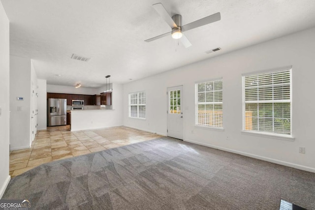 unfurnished living room featuring ceiling fan and light tile patterned floors