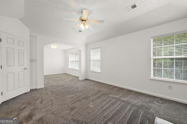 carpeted empty room featuring ceiling fan, lofted ceiling, and a textured ceiling