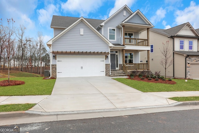 craftsman-style home featuring a porch, a front yard, a balcony, and a garage