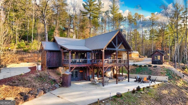 rear view of property with a patio area, an outdoor fire pit, and a wooden deck