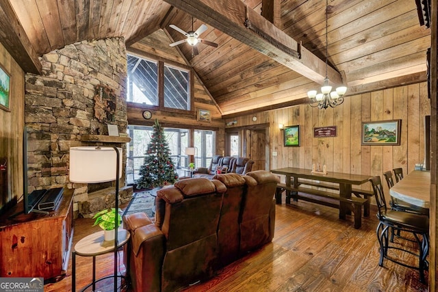 living room featuring lofted ceiling with beams, wooden walls, hardwood / wood-style flooring, wood ceiling, and ceiling fan with notable chandelier