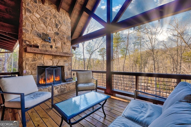 wooden deck with an outdoor stone fireplace