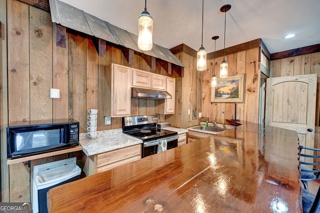 kitchen with stainless steel range with electric stovetop, hanging light fixtures, wooden walls, and sink