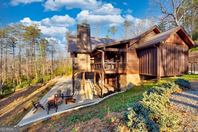 exterior space with an outdoor fire pit and a patio