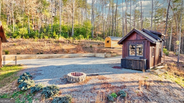 exterior space with a storage unit and a fire pit