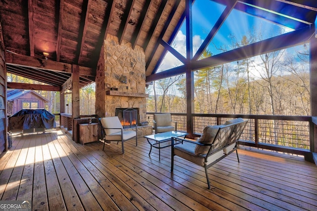 deck with an outdoor living space with a fireplace