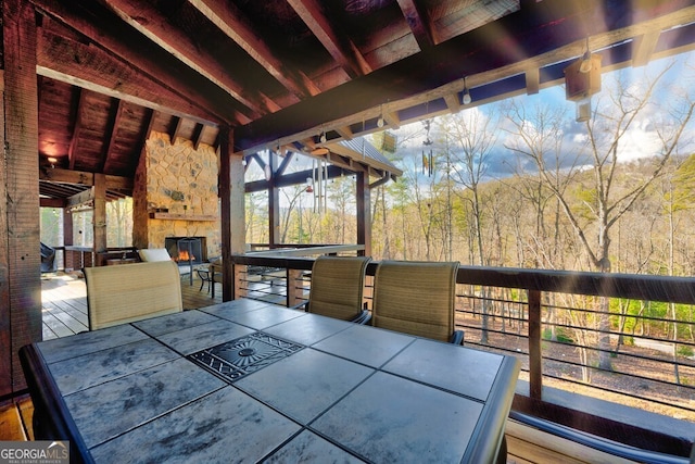 wooden deck with an outdoor stone fireplace