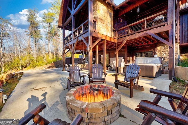 view of patio with an outdoor fire pit and a hot tub