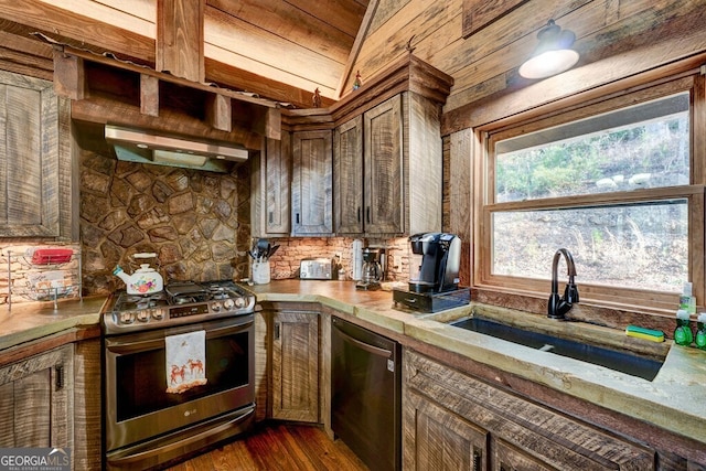 kitchen featuring gas stove, range hood, sink, black dishwasher, and dark wood-type flooring