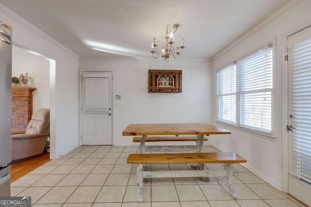 tiled dining area with a notable chandelier, a textured ceiling, and ornamental molding