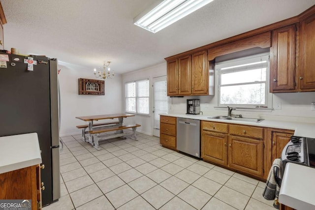 kitchen with stainless steel appliances, crown molding, sink, a notable chandelier, and light tile patterned flooring