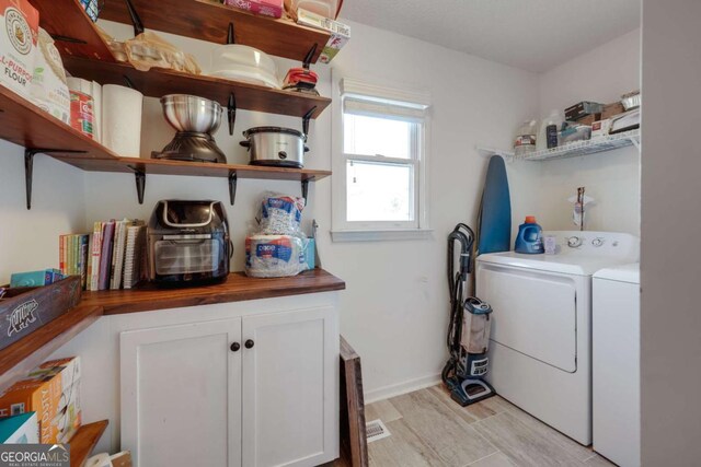 laundry area featuring cabinets and washing machine and dryer