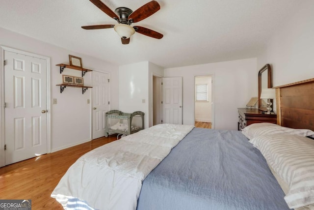 bedroom featuring ceiling fan, a textured ceiling, and light hardwood / wood-style flooring