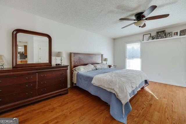 bedroom featuring ceiling fan, a textured ceiling, and hardwood / wood-style flooring