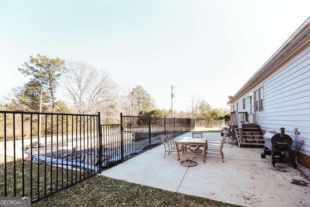 view of patio / terrace with area for grilling and a covered pool