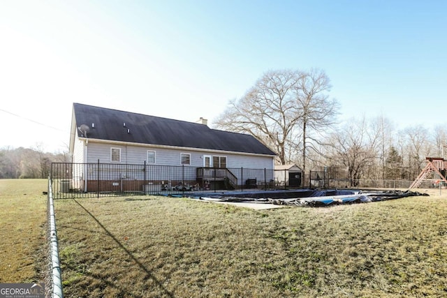 back of property featuring a lawn, a playground, and a covered pool