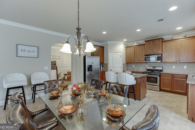 dining area featuring crown molding and a chandelier