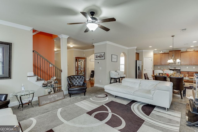 living room featuring ceiling fan, crown molding, and light colored carpet