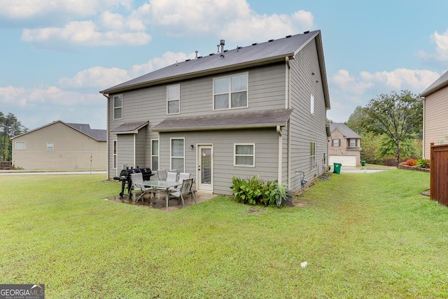 rear view of house featuring a lawn and a patio