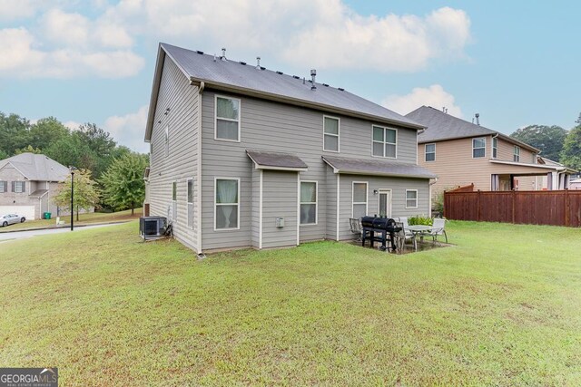 back of property featuring cooling unit and a yard