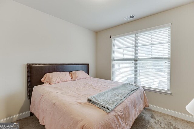 carpeted bedroom with multiple windows