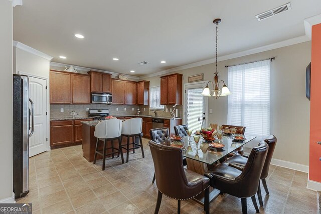 dining space featuring a notable chandelier, crown molding, and a wealth of natural light