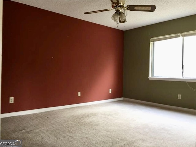 empty room with light carpet, a textured ceiling, and ceiling fan