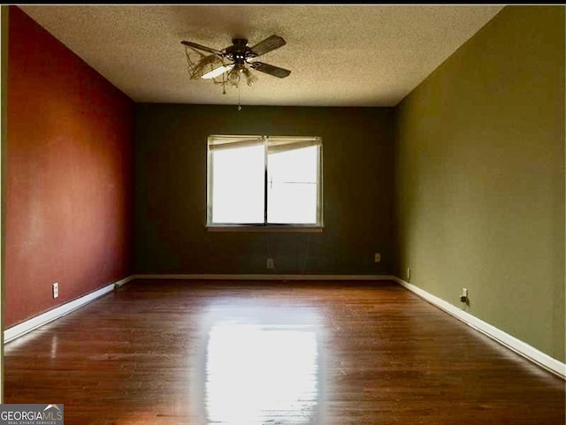 unfurnished room with a textured ceiling, dark hardwood / wood-style floors, and ceiling fan