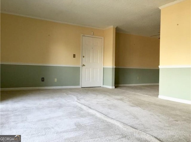 carpeted empty room with a textured ceiling and crown molding