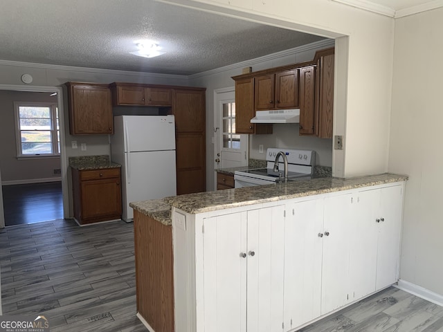 kitchen with white appliances, kitchen peninsula, crown molding, a textured ceiling, and light wood-type flooring