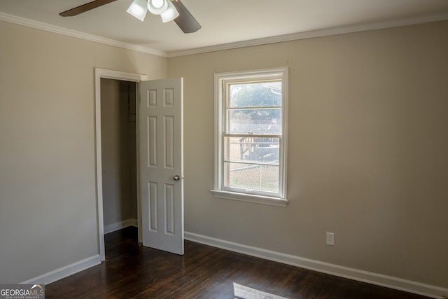 unfurnished bedroom with ornamental molding, ceiling fan, and dark hardwood / wood-style flooring