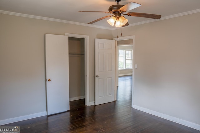 unfurnished bedroom featuring dark wood-type flooring, ceiling fan, ornamental molding, and a closet