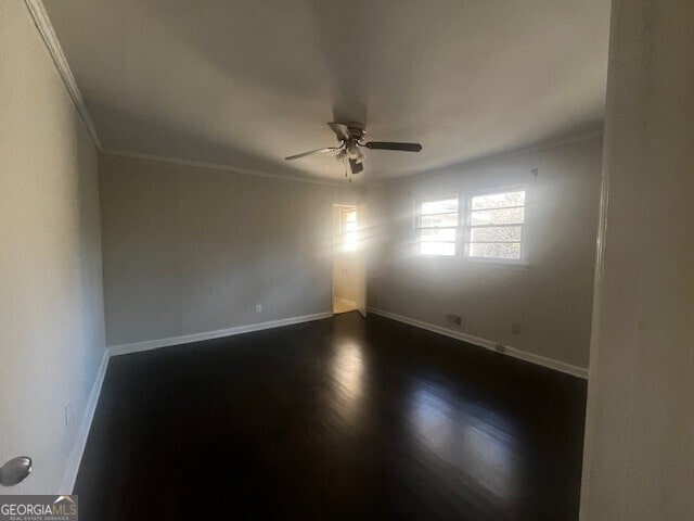 spare room featuring ornamental molding, ceiling fan, and dark hardwood / wood-style flooring