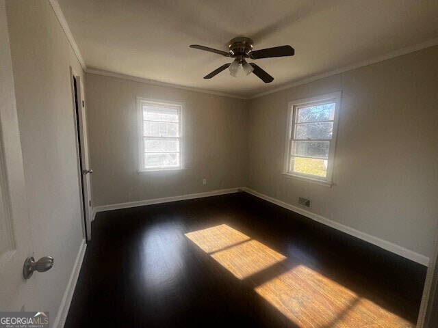 unfurnished room with ornamental molding, dark wood-type flooring, and ceiling fan