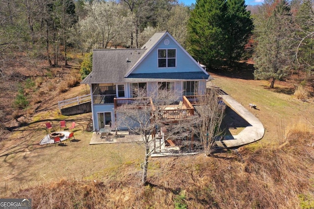 back of house featuring a patio, a deck, and a lawn