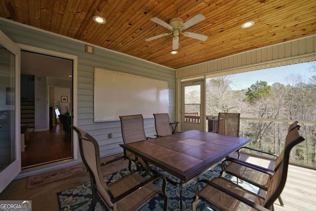 dining area featuring ceiling fan, wood walls, and wood ceiling