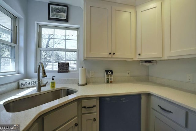 kitchen with white cabinetry, sink, and black dishwasher