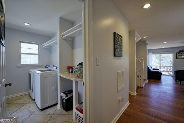 washroom with light hardwood / wood-style floors and washing machine and clothes dryer