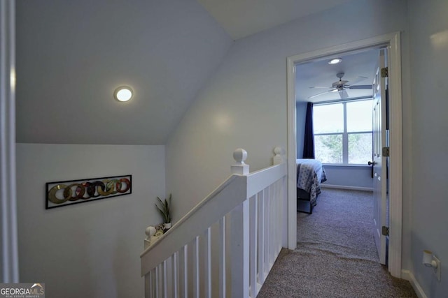 corridor featuring lofted ceiling and light carpet