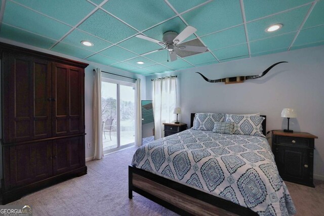 bedroom featuring access to exterior, light carpet, a drop ceiling, and ceiling fan