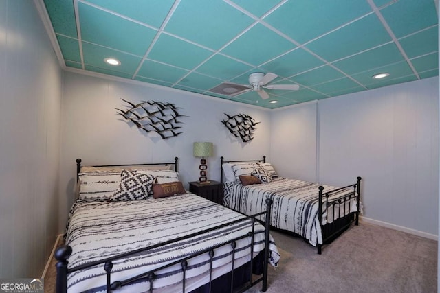 bedroom featuring carpet flooring, a drop ceiling, and ceiling fan