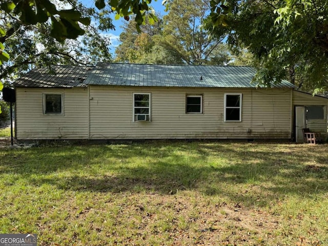 rear view of house featuring a lawn