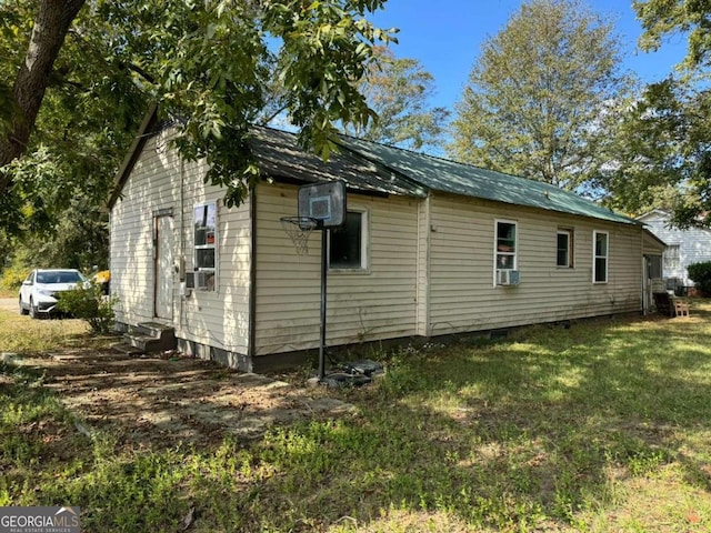 view of side of property with a yard and cooling unit