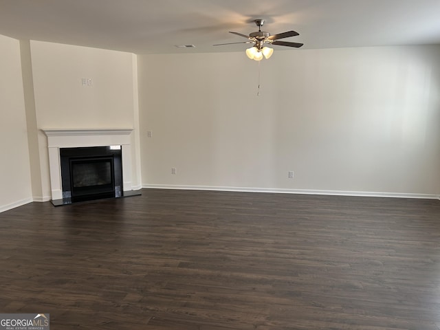 unfurnished living room featuring dark wood-type flooring and ceiling fan