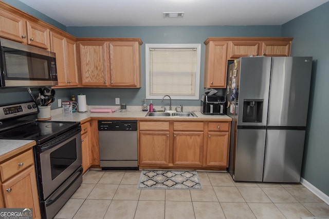 kitchen with sink, light tile patterned flooring, and appliances with stainless steel finishes